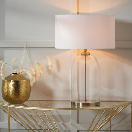 Clear glass table lamp with antique brass detail and white cotton shade